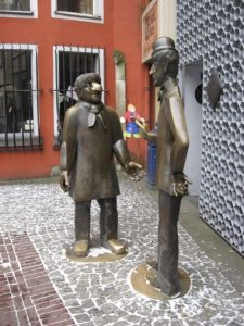 Tünnes und Schäl als Bronzefiguren vor einem Haus in der Kölner Altstadt